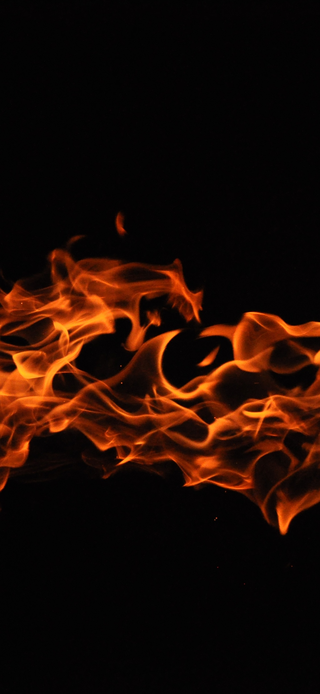 Feuer in Schwarzem Hintergrund Mit Schwarzem Hintergrund. Wallpaper in 1125x2436 Resolution