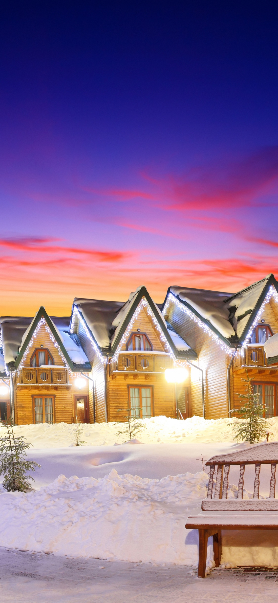 White and Brown Wooden House on Snow Covered Ground During Sunset. Wallpaper in 1125x2436 Resolution