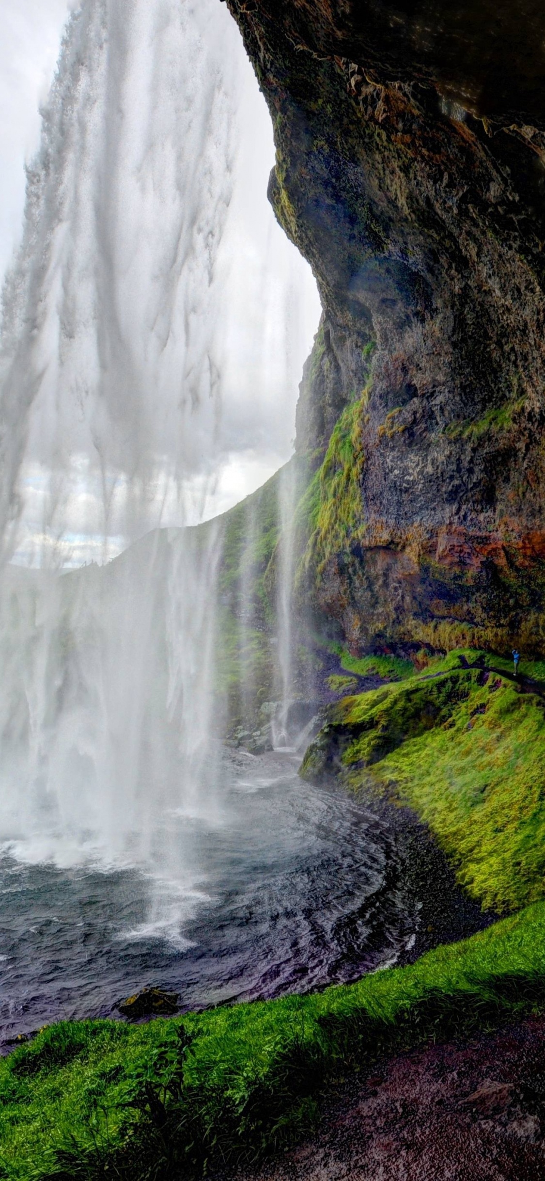Cascadas en el Campo de Hierba Verde Bajo el Cielo Nublado Gris Durante el Día. Wallpaper in 1125x2436 Resolution