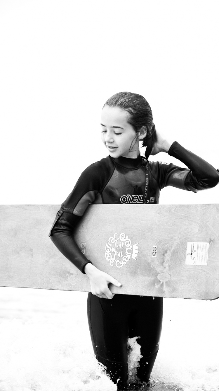 Foto en Escala de Grises Del Hombre Que Lleva Una Tabla de Surf. Wallpaper in 750x1334 Resolution