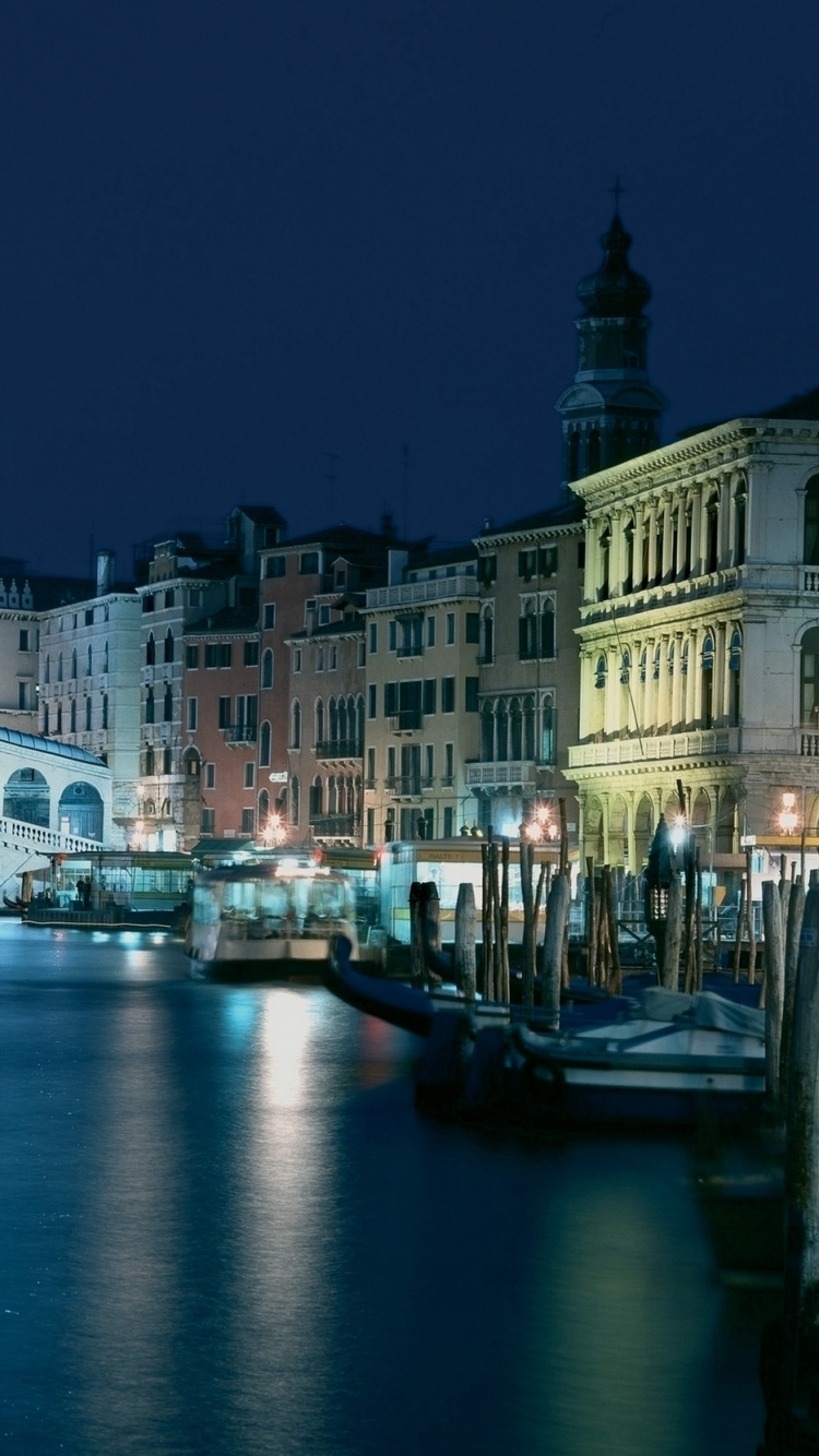 White Concrete Building Near River During Night Time. Wallpaper in 750x1334 Resolution