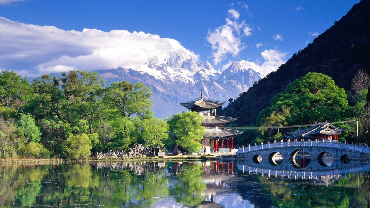 Red and White Wooden Bridge Over River Near Green Trees and Mountain Under Blue Sky And. Wallpaper in 1280x720 Resolution