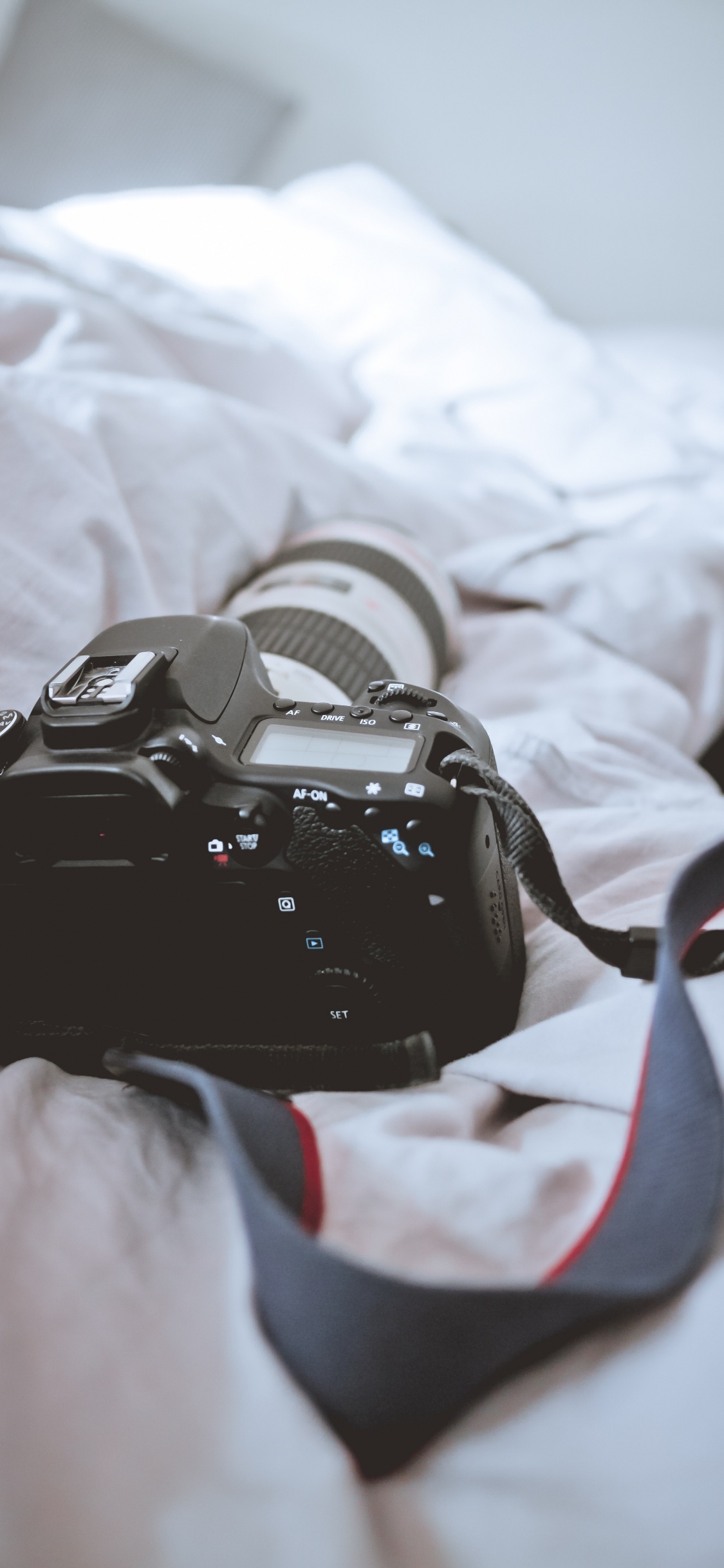 Schwarze DSLR-Kamera Auf Weißem Textil. Wallpaper in 1125x2436 Resolution