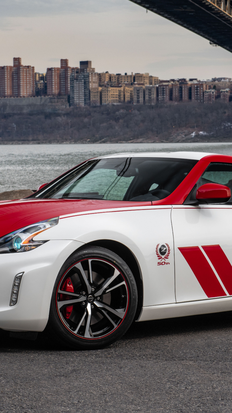 White and Red Porsche 911 Parked on Gray Pavement Near Body of Water During Daytime. Wallpaper in 750x1334 Resolution