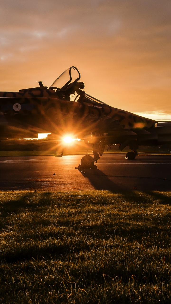 Schwarzer Hubschrauber Auf Grüner Wiese Bei Sonnenuntergang. Wallpaper in 720x1280 Resolution