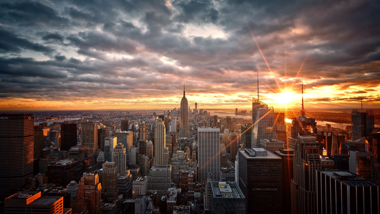 Skyline Der Stadt Unter Orange Und Grau Bewölktem Himmel Bei Sonnenuntergang. Wallpaper in 1280x720 Resolution