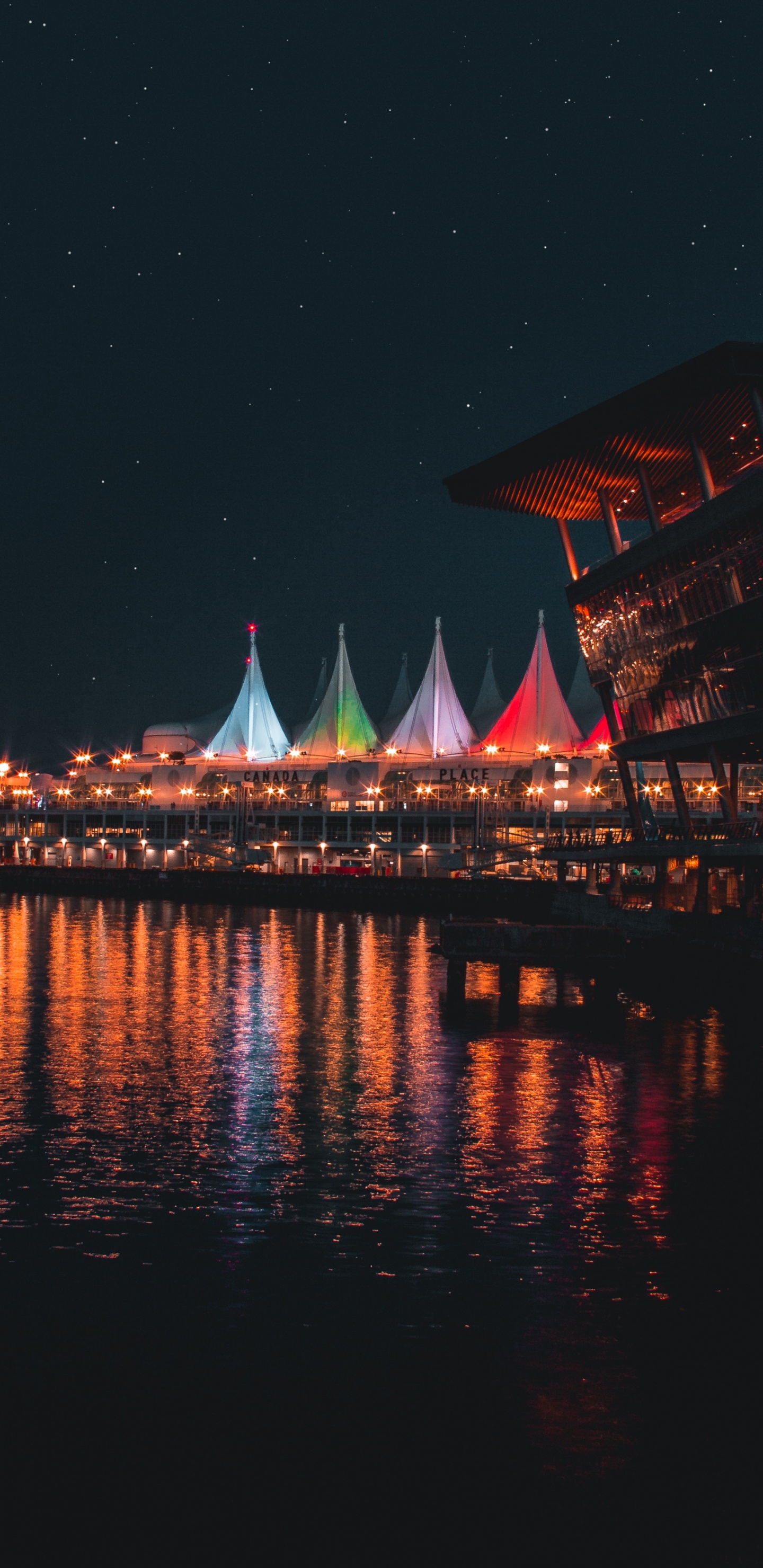 Bâtiment Marron et Blanc Près D'un Plan D'eau Pendant la Nuit. Wallpaper in 1440x2960 Resolution