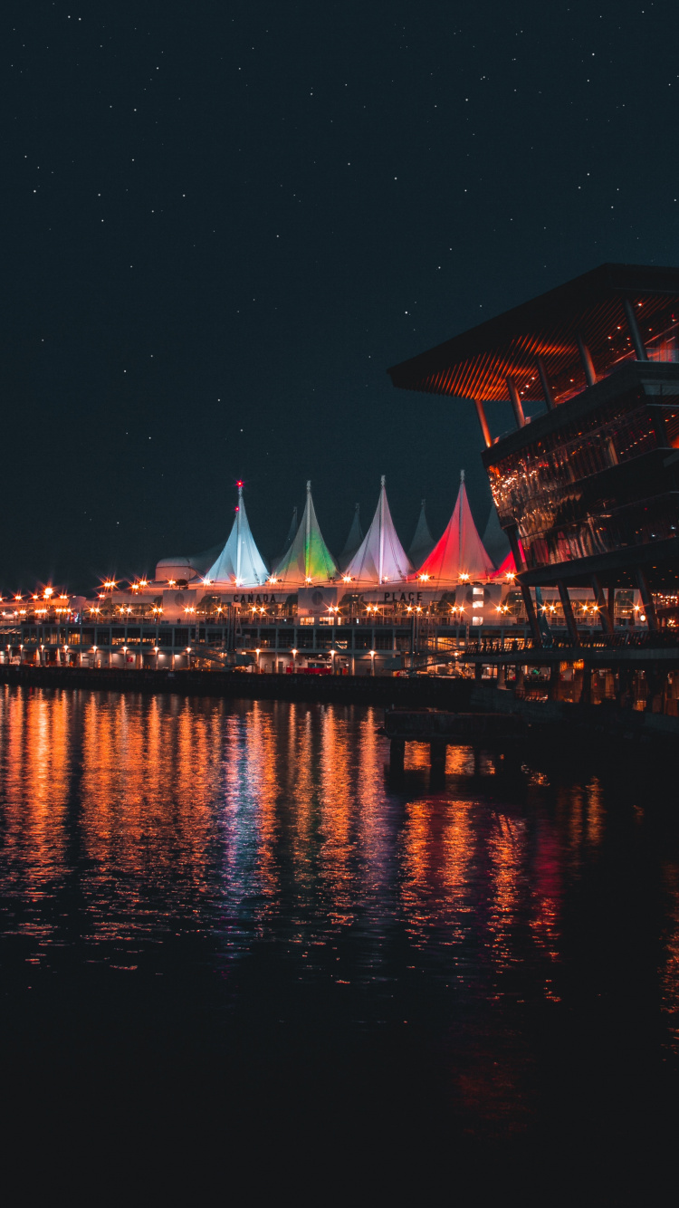 Bâtiment Marron et Blanc Près D'un Plan D'eau Pendant la Nuit. Wallpaper in 750x1334 Resolution