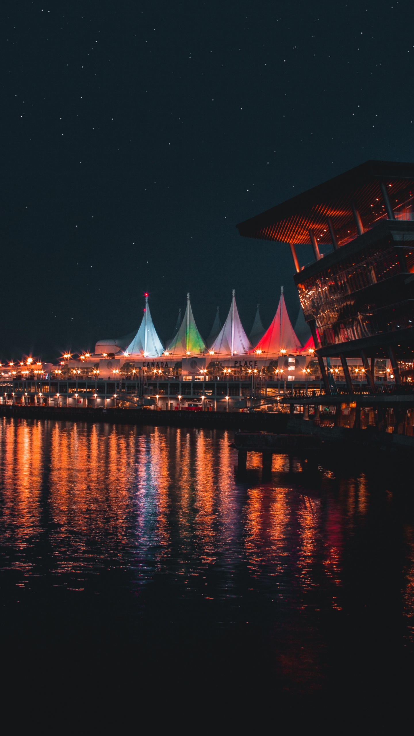 Brown and White Building Near Body of Water During Night Time. Wallpaper in 1440x2560 Resolution