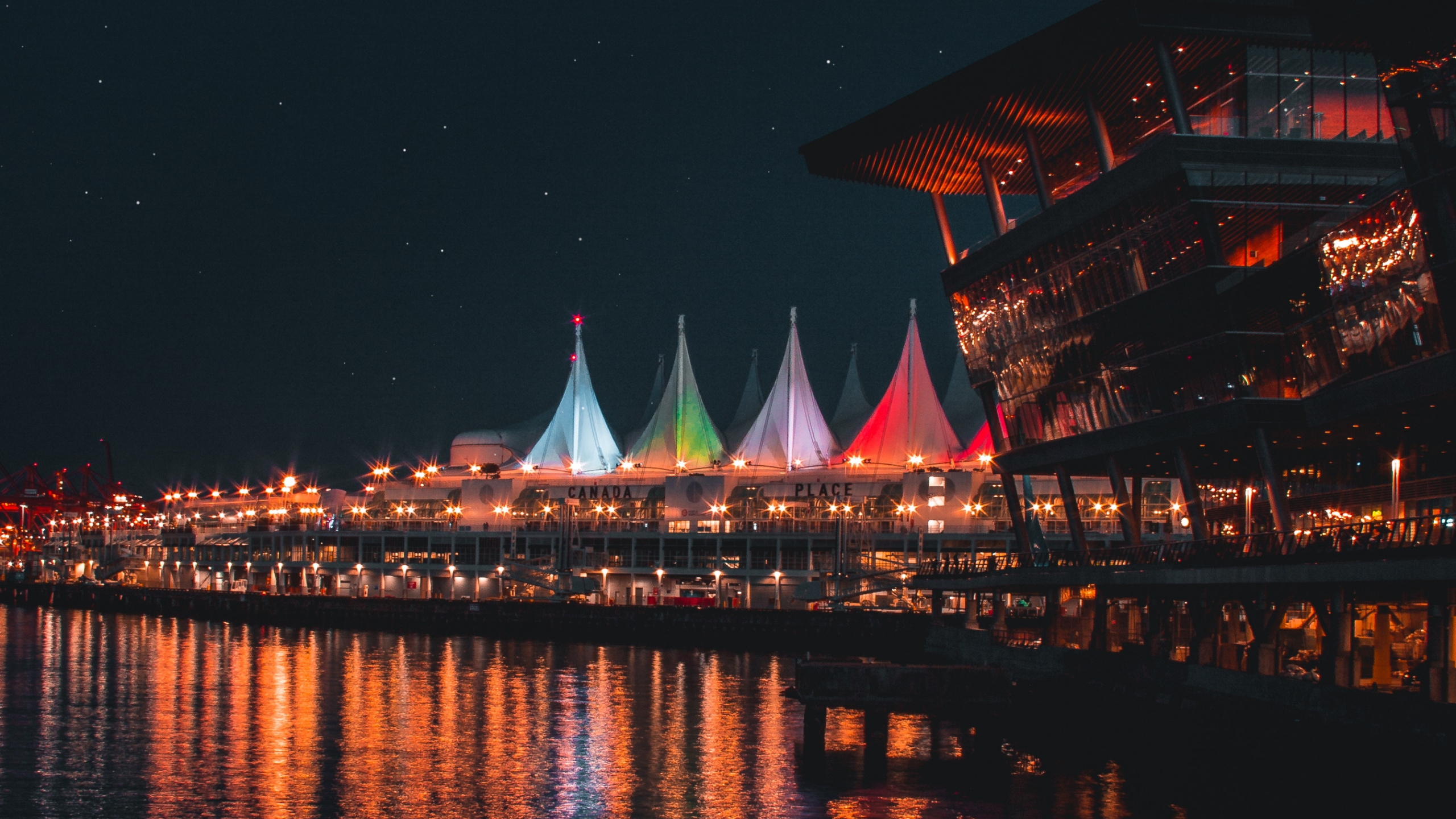 Brown and White Building Near Body of Water During Night Time. Wallpaper in 2560x1440 Resolution