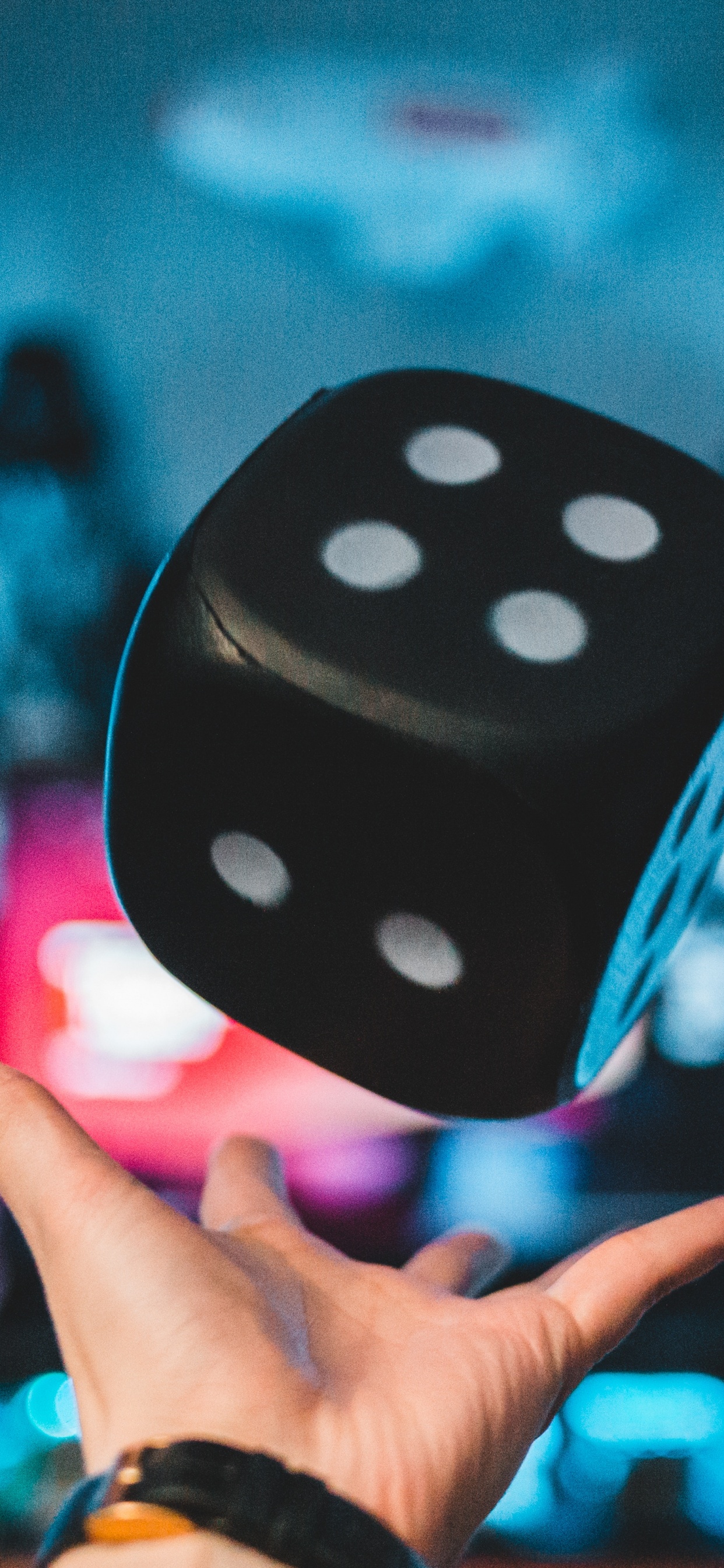 Person Holding Purple and White Polka Dot Dice. Wallpaper in 1242x2688 Resolution