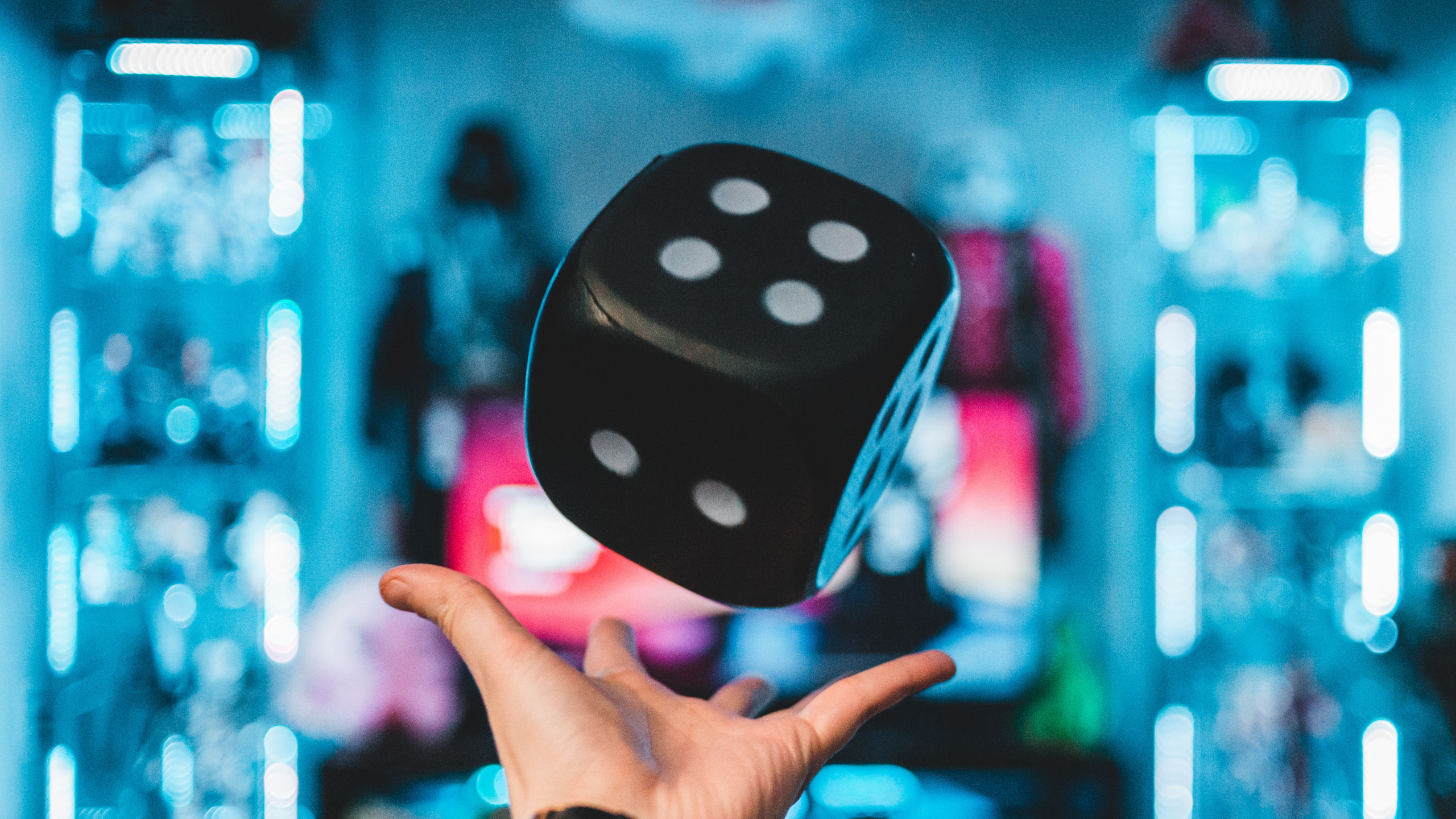 Person Holding Purple and White Polka Dot Dice. Wallpaper in 2560x1440 Resolution