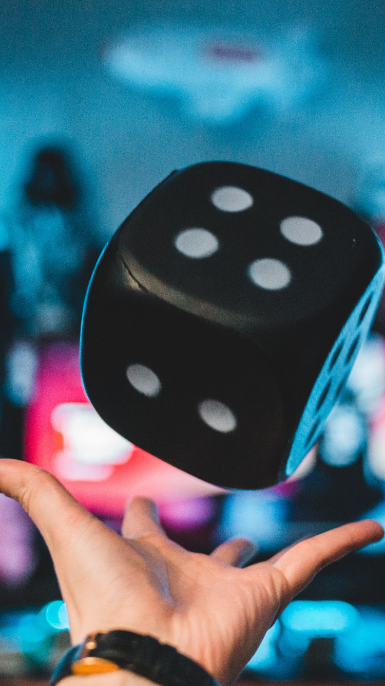 Person Holding Purple and White Polka Dot Dice. Wallpaper in 750x1334 Resolution