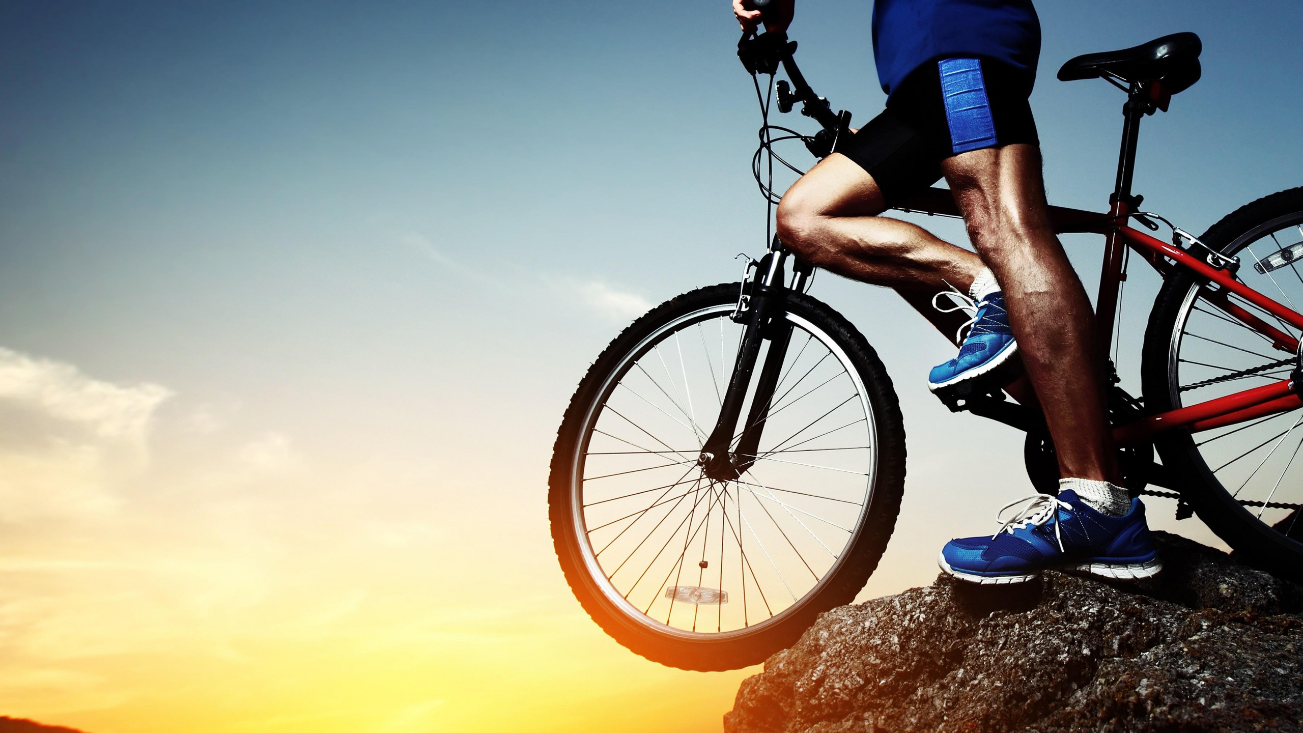 Hombre Con Camisa Azul Montando Bicicleta Negra Durante la Puesta de Sol. Wallpaper in 2560x1440 Resolution