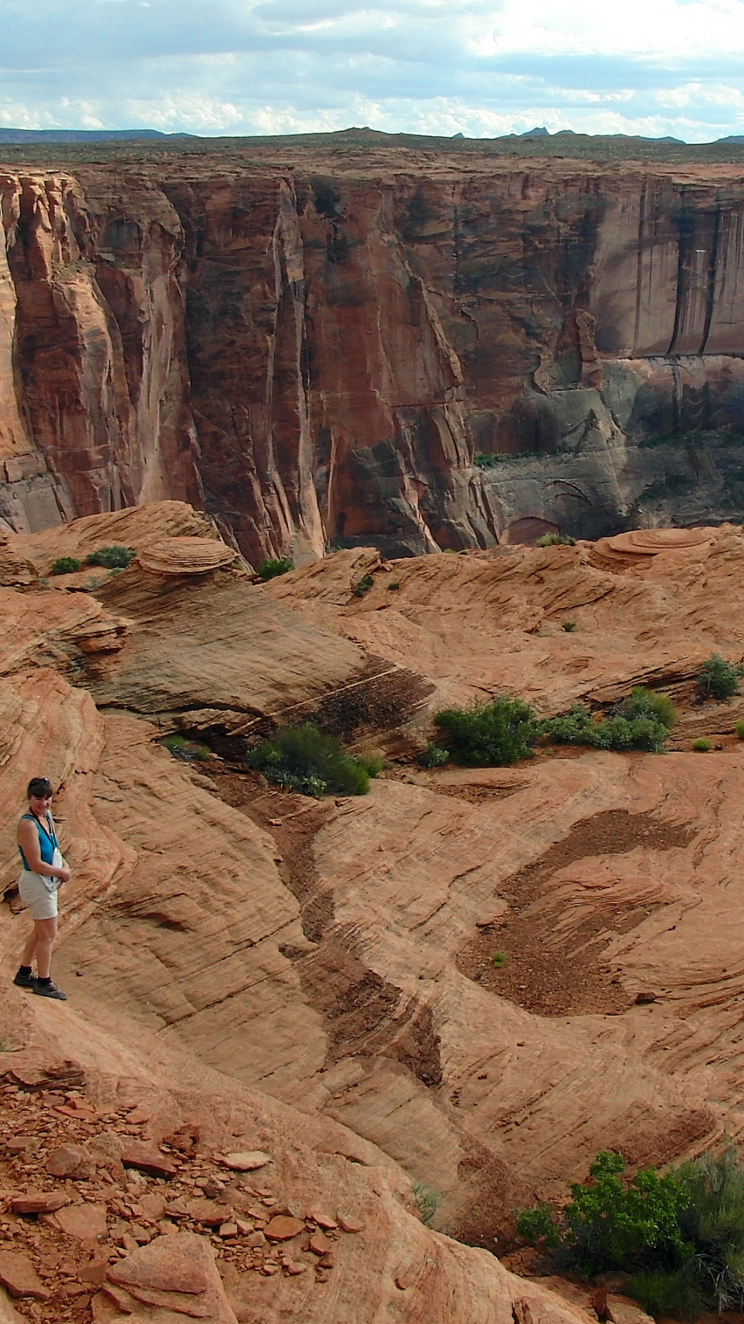 Mujer Con Camisa Blanca y Pantalones Vaqueros Azules Caminando Sobre la Montaña Rocosa Marrón Durante el Día. Wallpaper in 1080x1920 Resolution