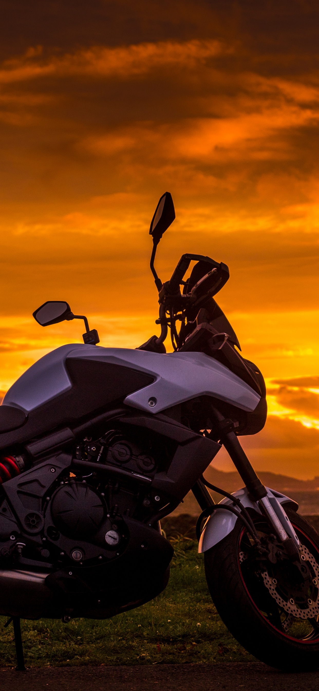 Black and White Sports Bike on Green Grass Field During Sunset. Wallpaper in 1242x2688 Resolution