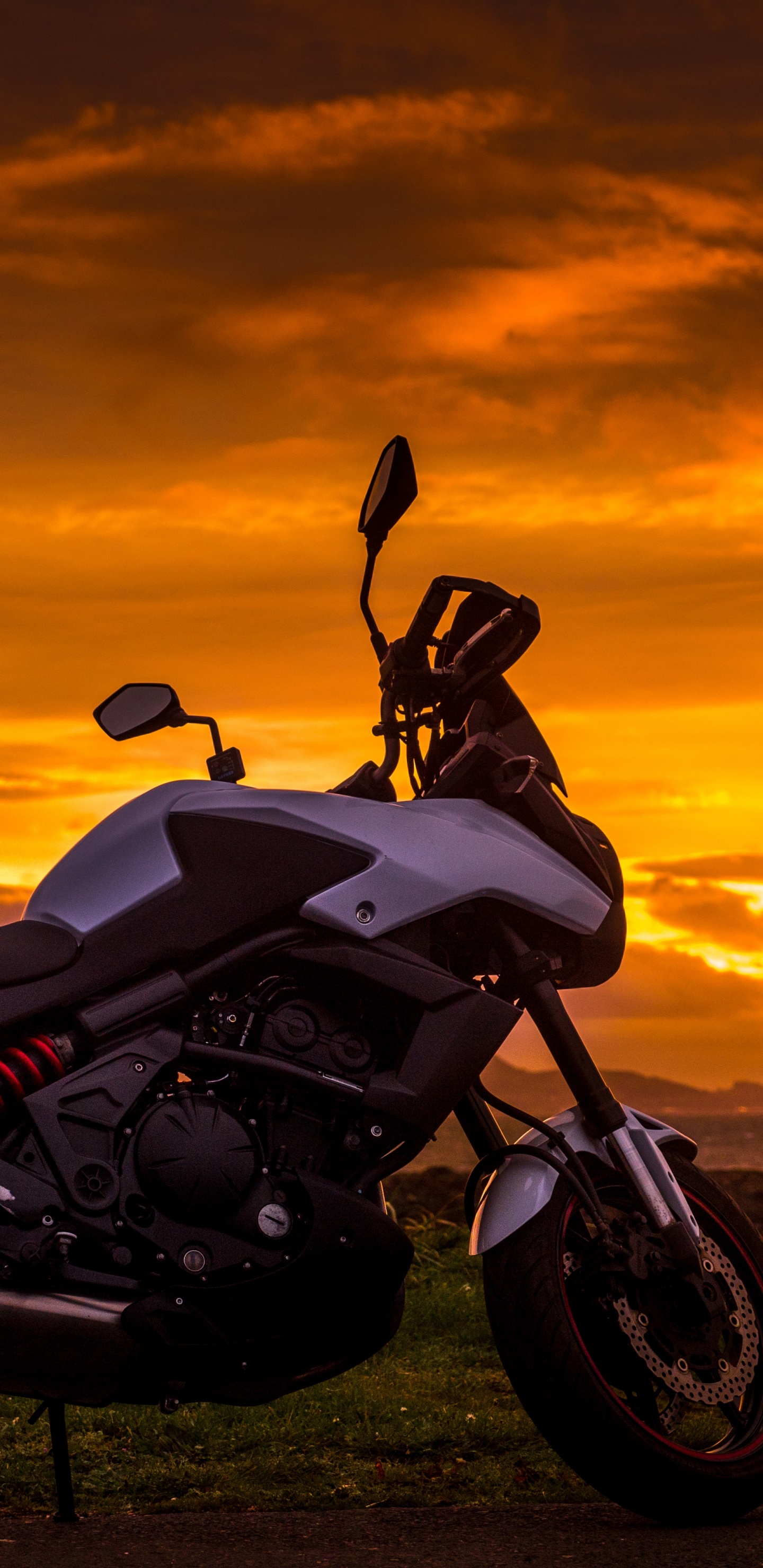 Black and White Sports Bike on Green Grass Field During Sunset. Wallpaper in 1440x2960 Resolution