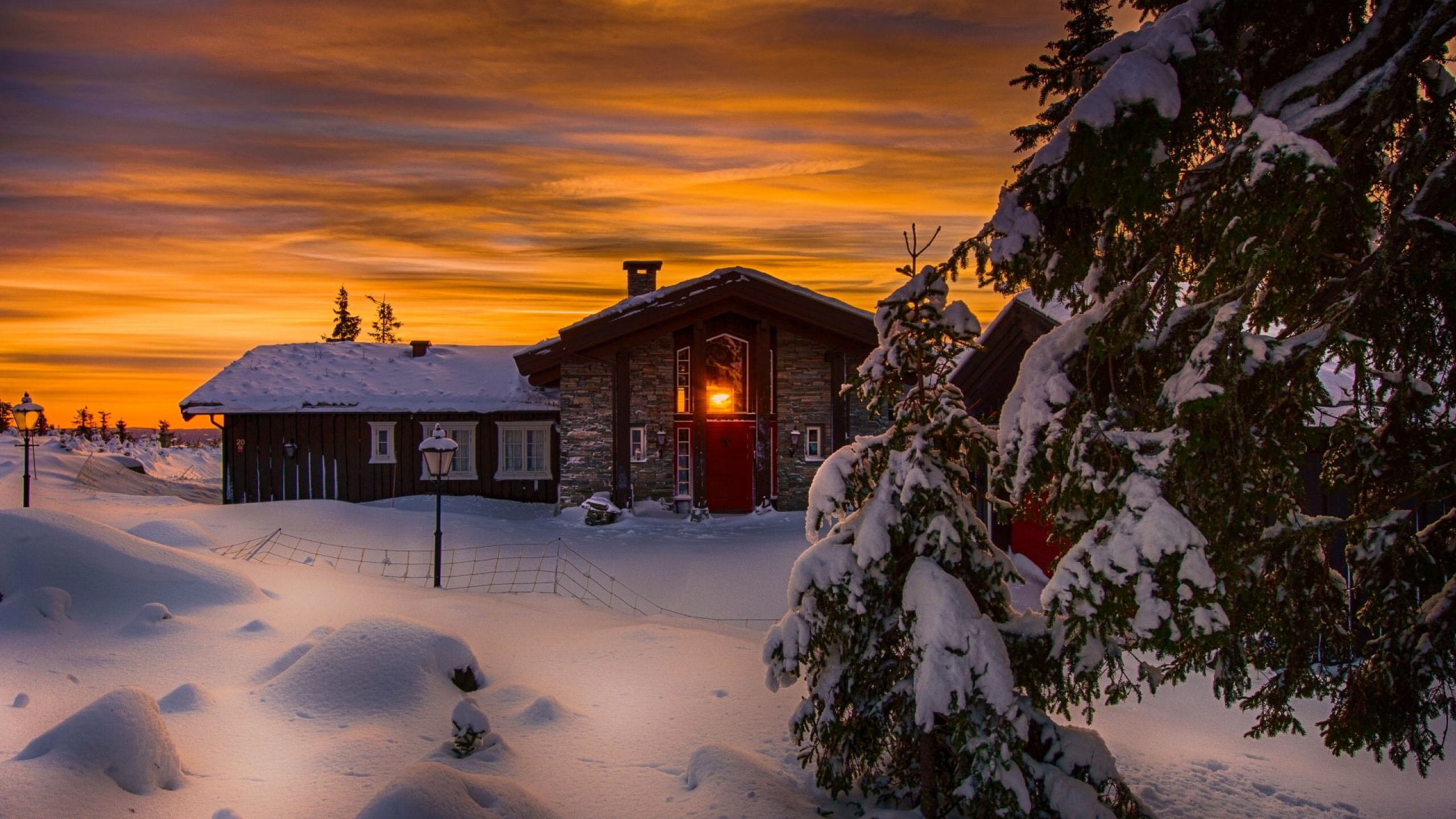Braunes Holzhaus Bei Sonnenuntergang Mit Schnee Bedeckt. Wallpaper in 2560x1440 Resolution