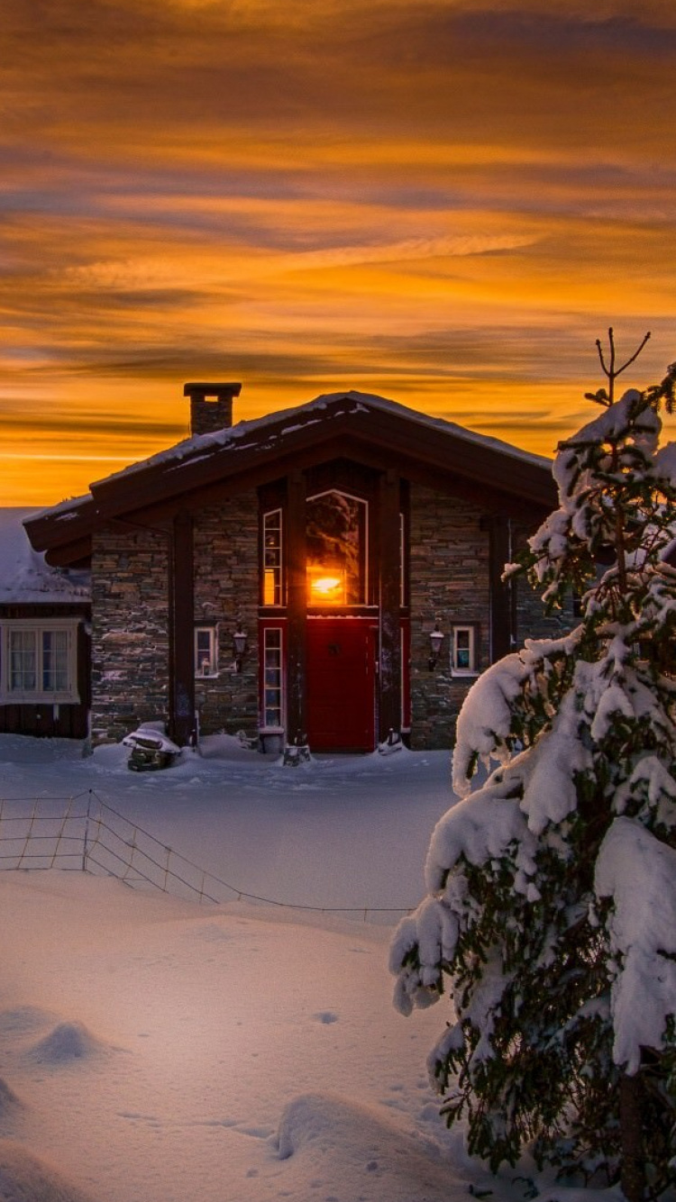 Maison en Bois Brune Couverte de Neige Pendant le Coucher du Soleil. Wallpaper in 750x1334 Resolution