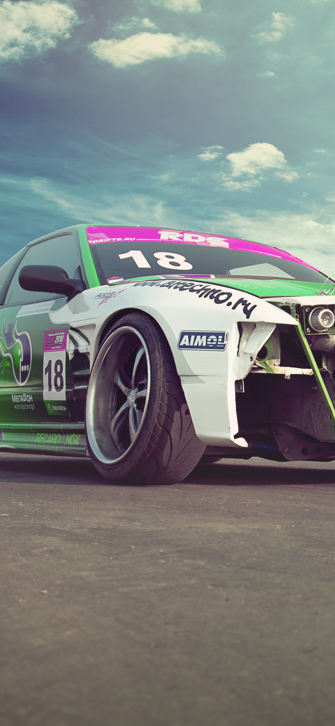 Grüner Und Schwarzer Chevrolet Camaro Auf Grauer Asphaltstraße Unter Weißem Bewölktem Himmel Tagsüber. Wallpaper in 1125x2436 Resolution