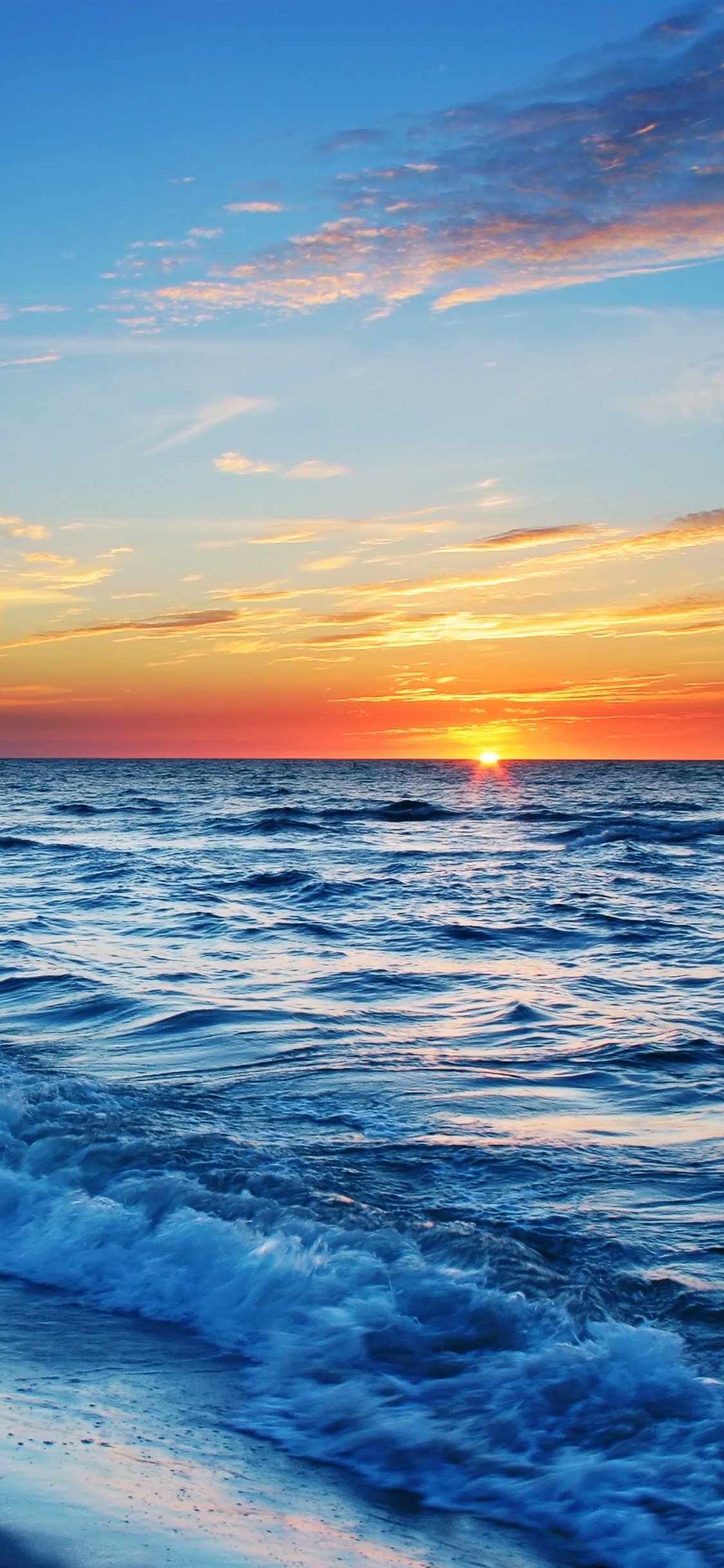 Les Vagues de L'océan S'écrasent Sur le Rivage au Coucher du Soleil. Wallpaper in 1125x2436 Resolution