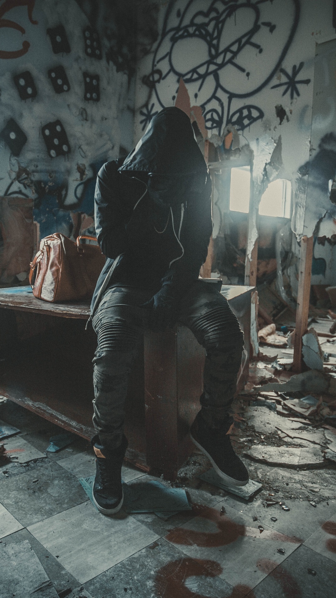 Mann in Schwarzer Jacke Sitzt Auf Brauner Holzbank. Wallpaper in 1080x1920 Resolution