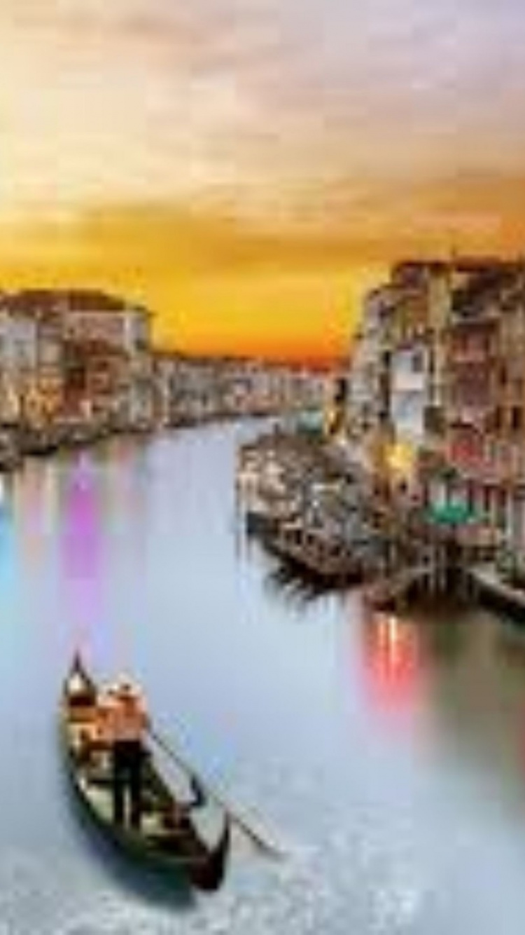 Barco en el Río Cerca de Edificios Durante la Puesta de Sol. Wallpaper in 750x1334 Resolution