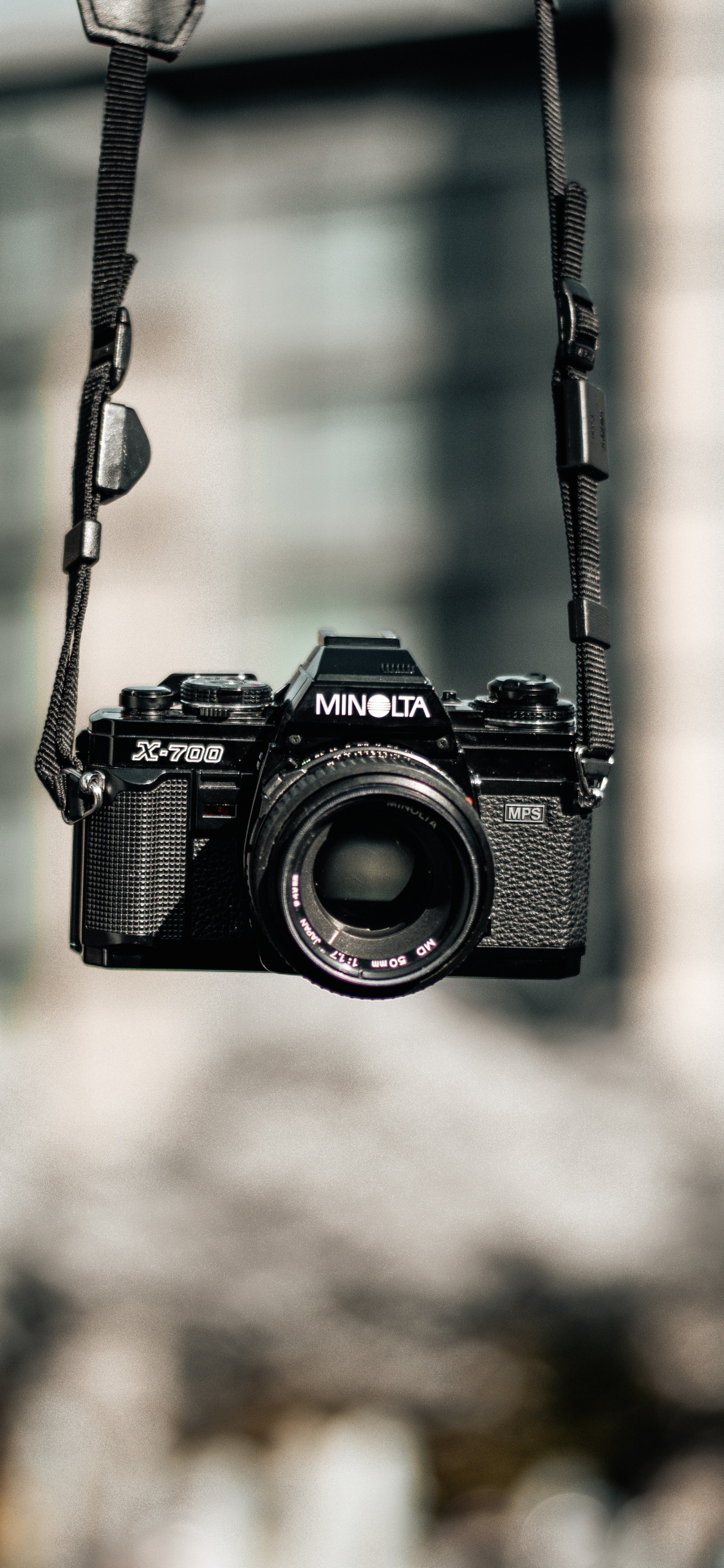 Schwarze Nikon Dslr Kamera Hängt an Schwarzem Metalldraht. Wallpaper in 1125x2436 Resolution