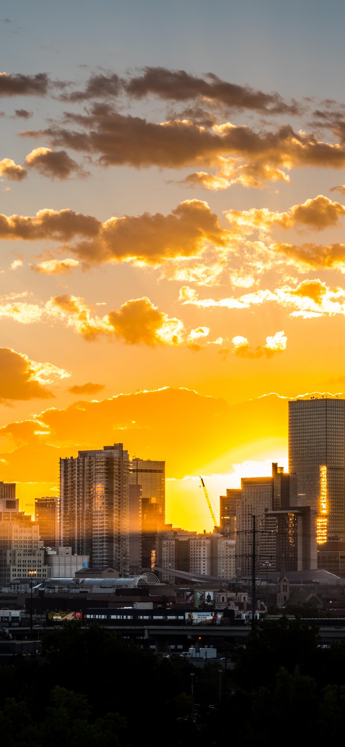 Skyline Der Stadt Unter Bewölktem Himmel Bei Sonnenuntergang. Wallpaper in 1125x2436 Resolution
