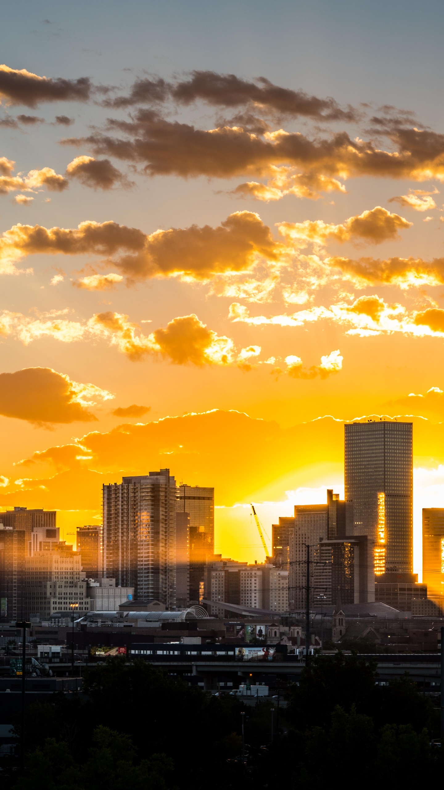 Skyline Der Stadt Unter Bewölktem Himmel Bei Sonnenuntergang. Wallpaper in 1440x2560 Resolution