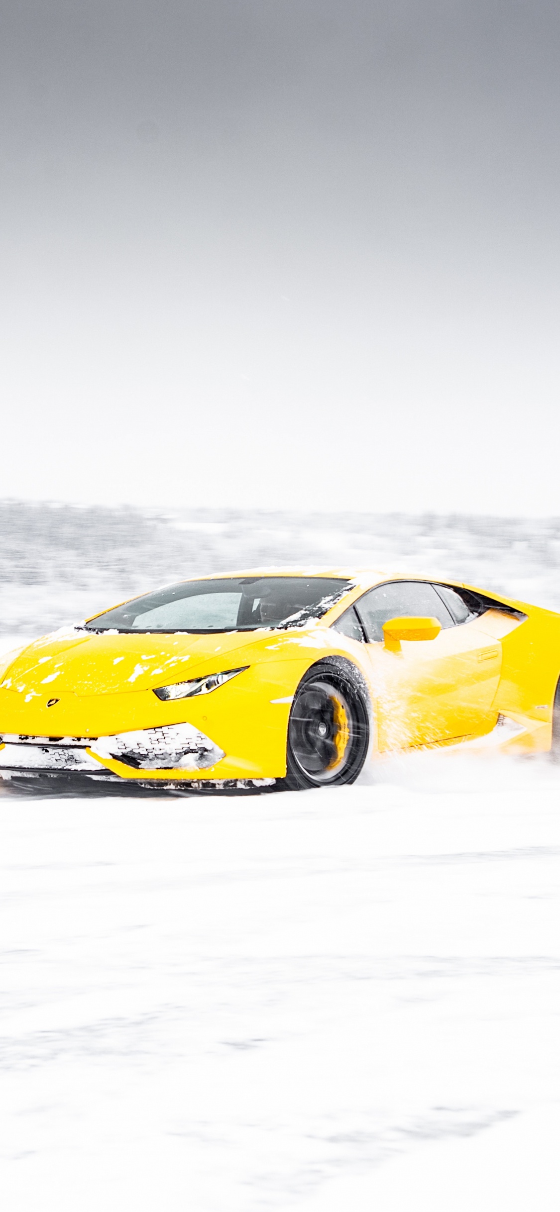 Yellow Ferrari 458 Italia on Snow Covered Ground. Wallpaper in 1125x2436 Resolution