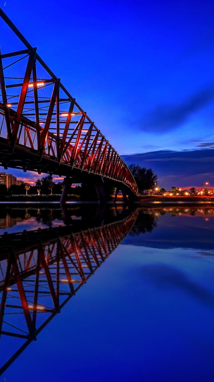Braune Holzbrücke Über Den Fluss Während Der Nacht. Wallpaper in 750x1334 Resolution
