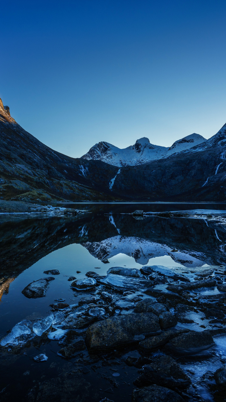 Snow Covered Mountain Near Body of Water During Daytime. Wallpaper in 750x1334 Resolution
