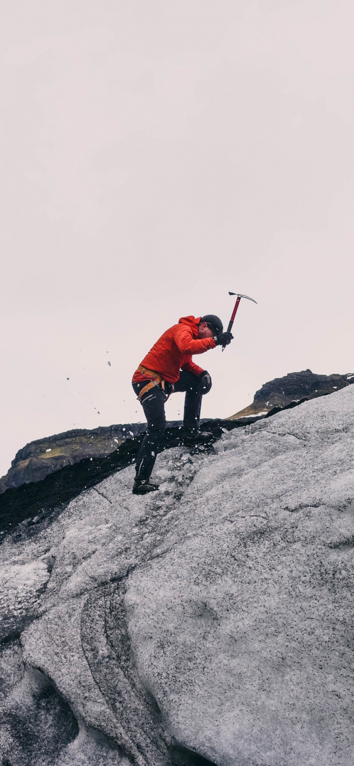 Person in Red Jacket and Black Pants Standing on Gray Rock Mountain During Daytime. Wallpaper in 1125x2436 Resolution