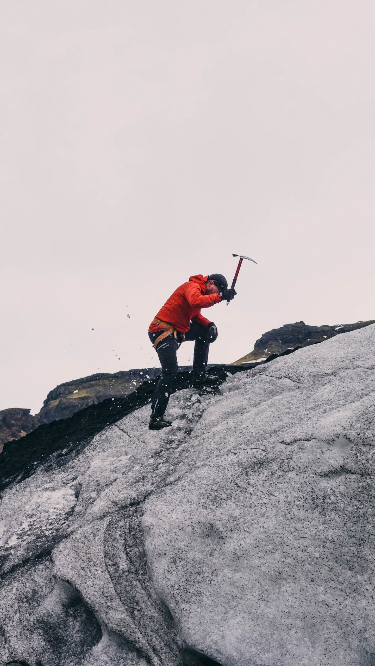Person in Red Jacket and Black Pants Standing on Gray Rock Mountain During Daytime. Wallpaper in 1440x2560 Resolution