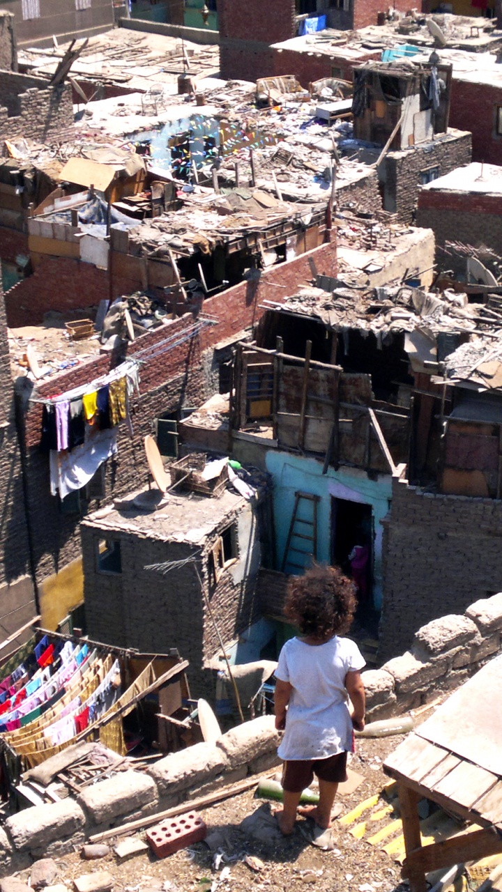 Hombre Con Camiseta Blanca y Pantalones Vaqueros Azules de Pie Sobre un Edificio de Hormigón Marrón Durante el Día. Wallpaper in 720x1280 Resolution