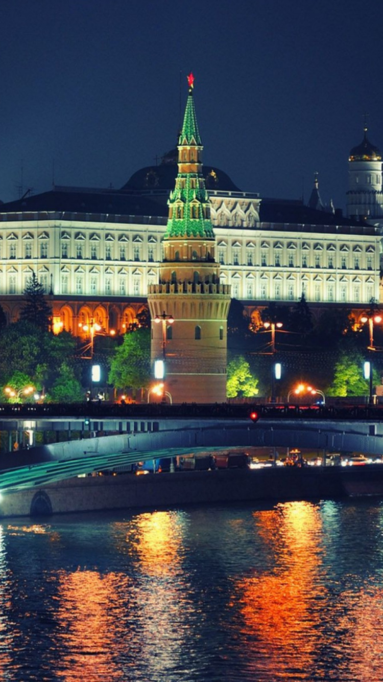 White Concrete Building Near Body of Water During Nighttime. Wallpaper in 750x1334 Resolution