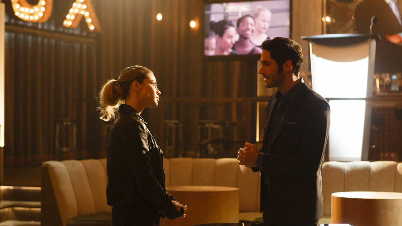 Hombre de Traje Negro de Pie Junto a Una Mujer Con Camisa de Manga Larga Negra. Wallpaper in 1280x720 Resolution