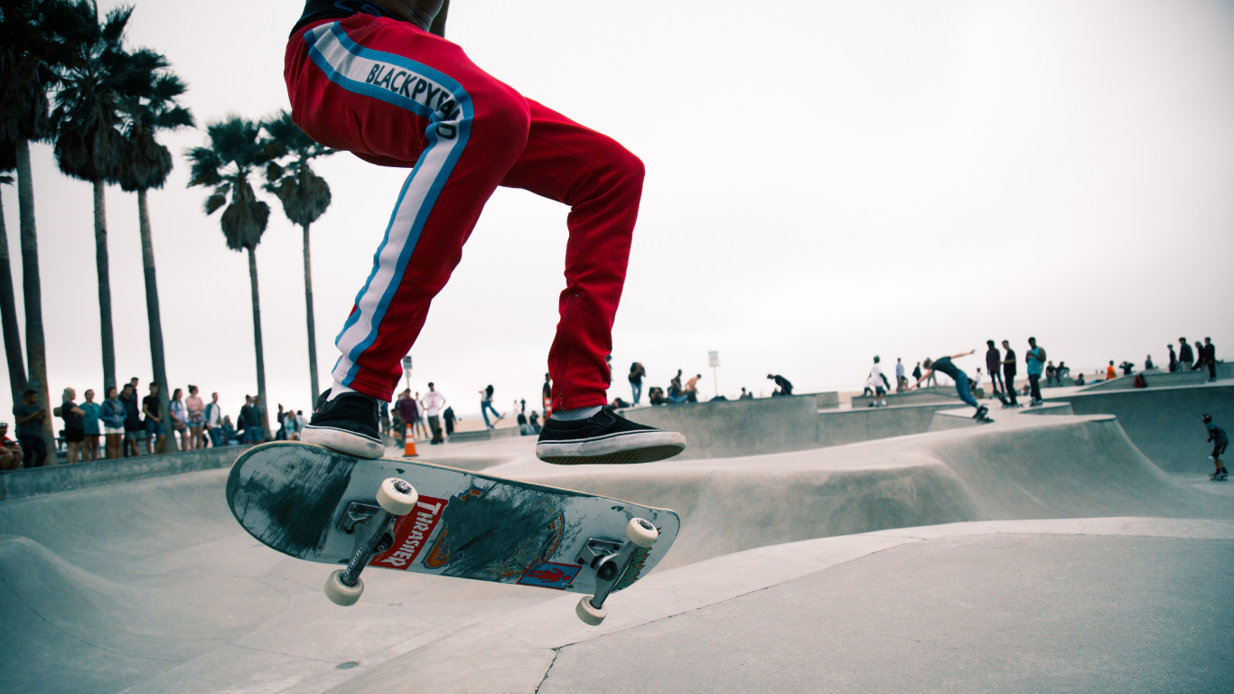 Man in Red Pants and Black and White Sneakers Riding Skateboard. Wallpaper in 1366x768 Resolution