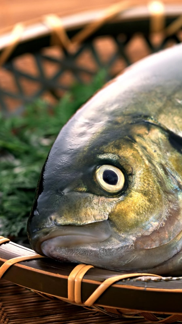 Silberner Fisch Auf Braunem Flechtkorb. Wallpaper in 720x1280 Resolution