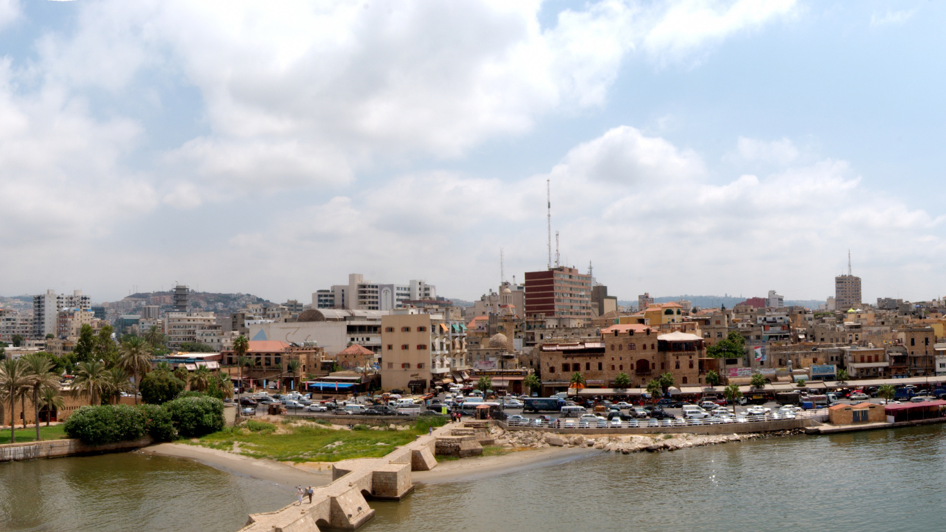 City Buildings Near River Under White Cloudy Sky During Daytime. Wallpaper in 1366x768 Resolution