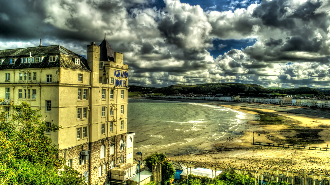 Brown Concrete Building Near Body of Water Under Cloudy Sky During Daytime. Wallpaper in 1366x768 Resolution