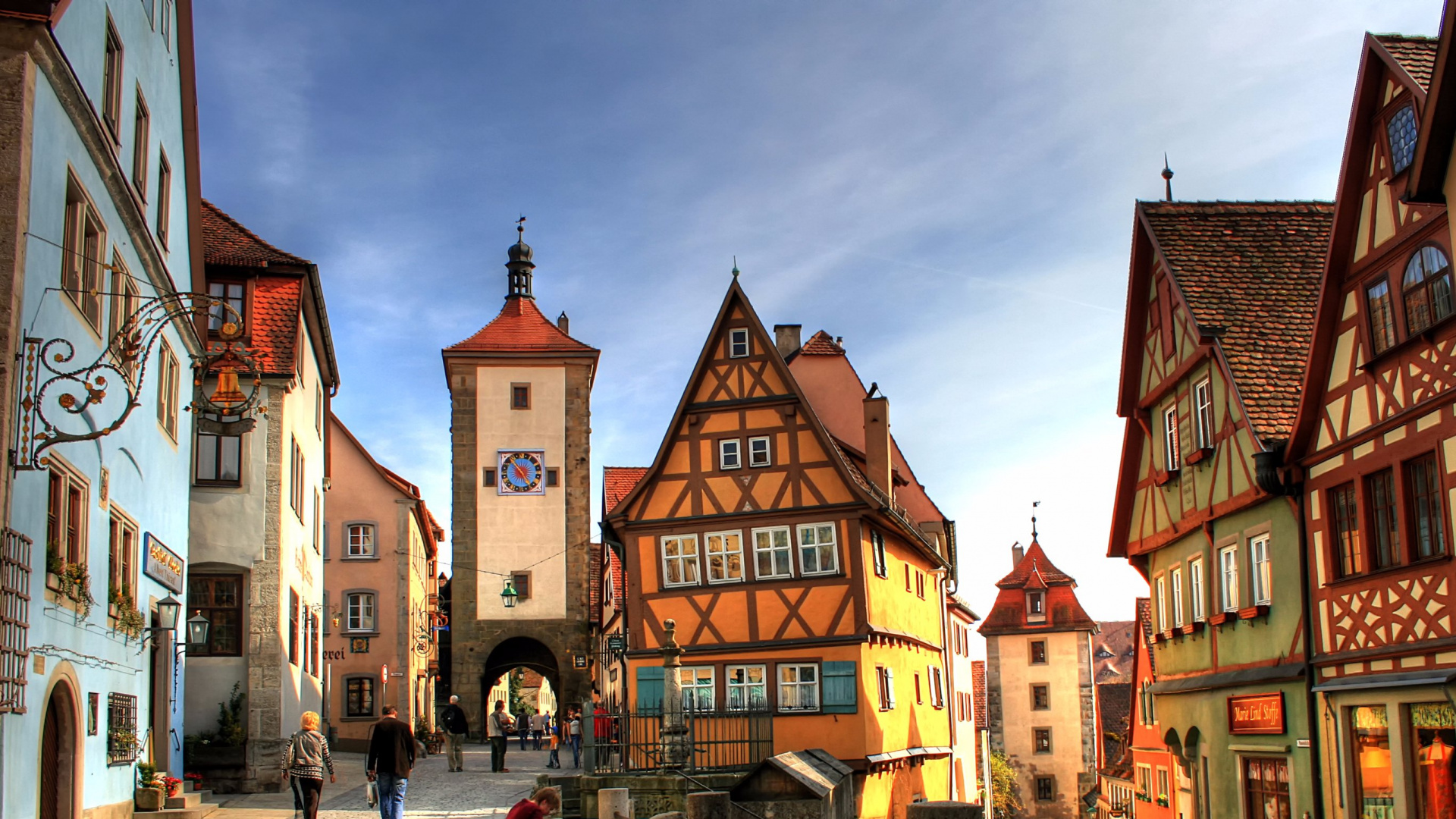 Leute, Die Tagsüber Auf Dem Bürgersteig in Der Nähe Eines Braunen Betongebäudes Gehen. Wallpaper in 1920x1080 Resolution