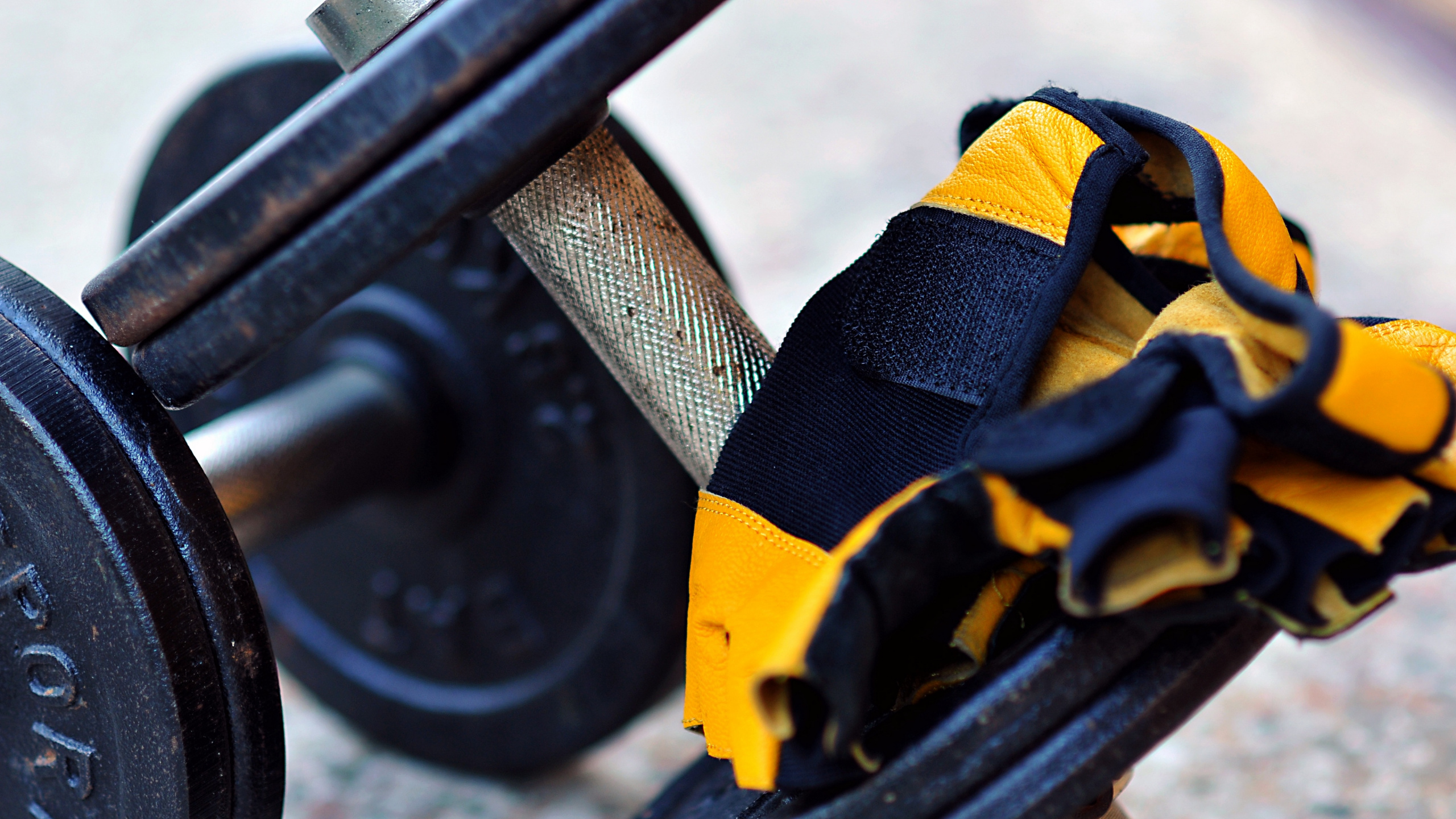 Black and Yellow Dumbbell on Yellow Textile. Wallpaper in 2560x1440 Resolution