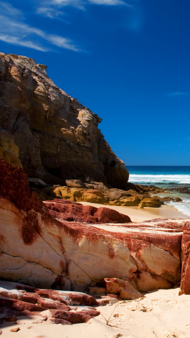 Brown Rock Formation Near Sea Under Blue Sky During Daytime. Wallpaper in 750x1334 Resolution