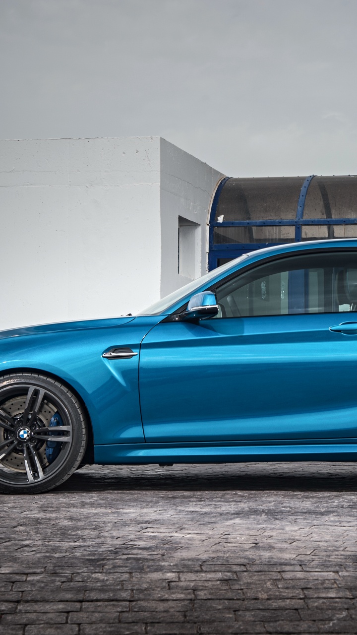 Blue Sedan Parked Beside White Wall. Wallpaper in 720x1280 Resolution