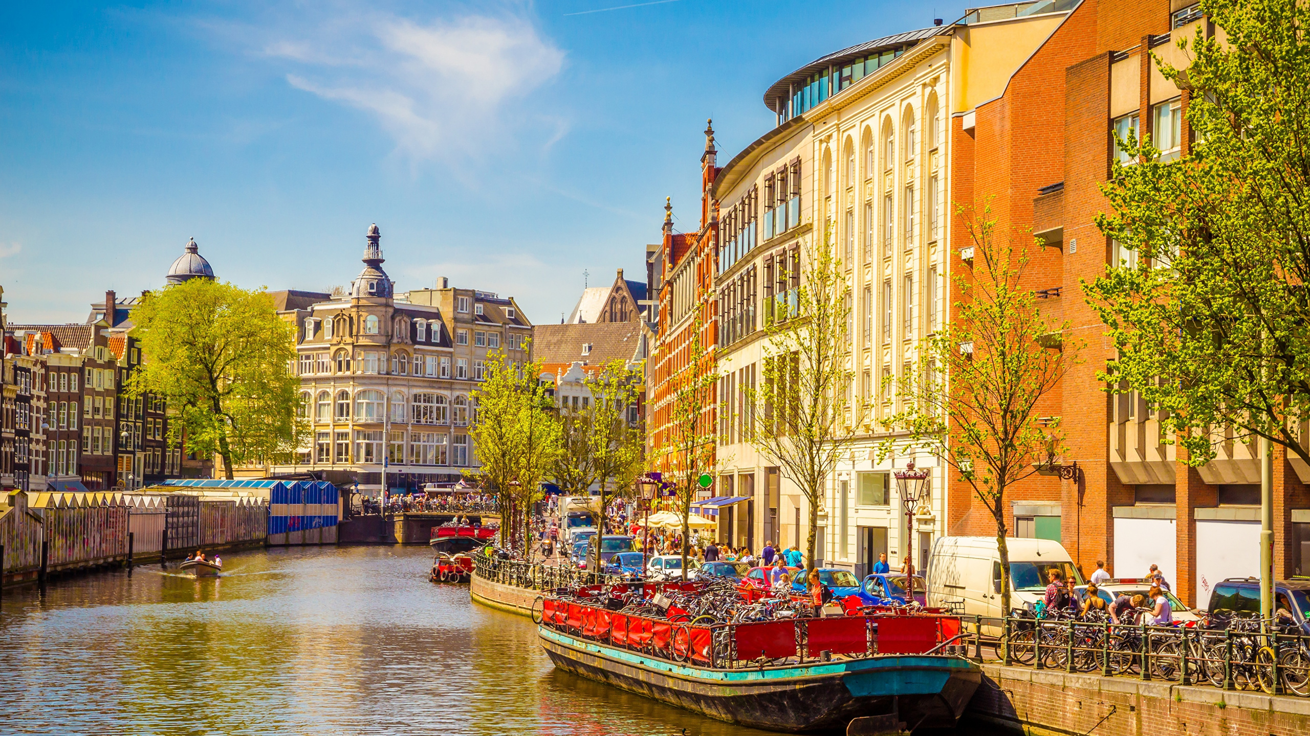 Bateau Rouge Sur la Rivière Près D'un Bâtiment en Béton Brun Pendant la Journée. Wallpaper in 2560x1440 Resolution