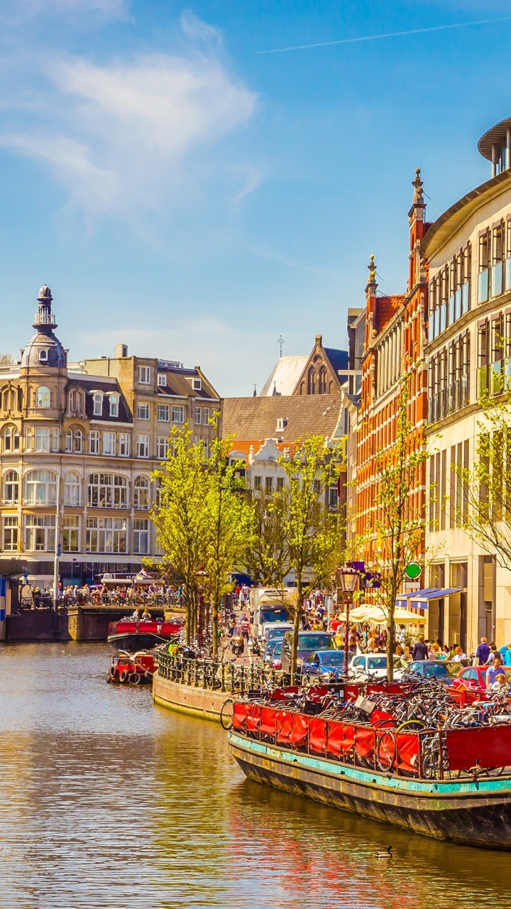 Bateau Rouge Sur la Rivière Près D'un Bâtiment en Béton Brun Pendant la Journée. Wallpaper in 720x1280 Resolution