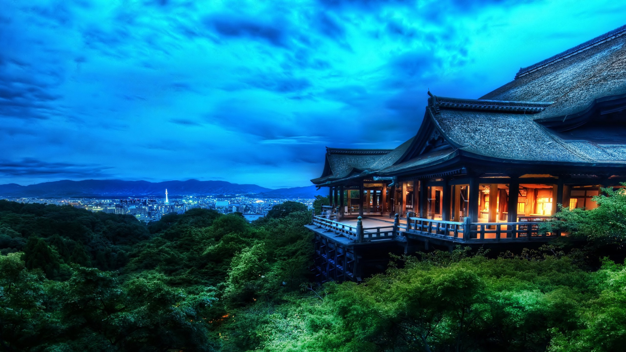 Brown Wooden House on Green Forest During Night Time. Wallpaper in 2560x1440 Resolution