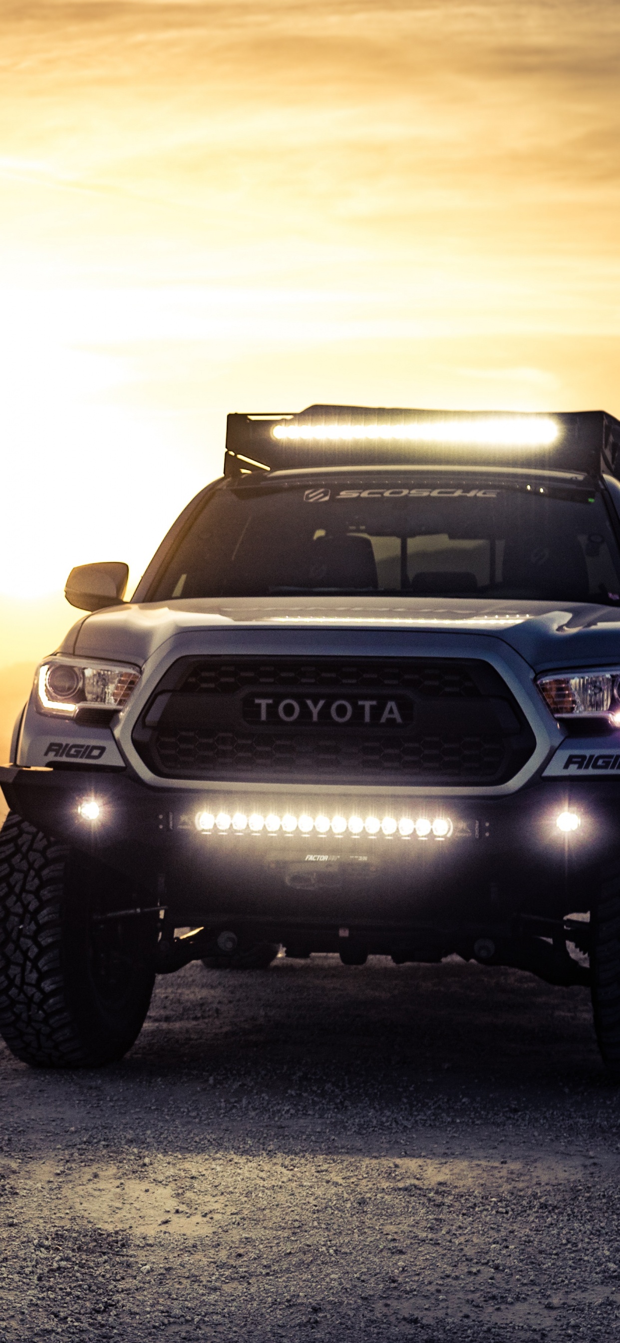 Schwarzer Nissan Suv Auf Braunem Sand Bei Sonnenuntergang. Wallpaper in 1242x2688 Resolution